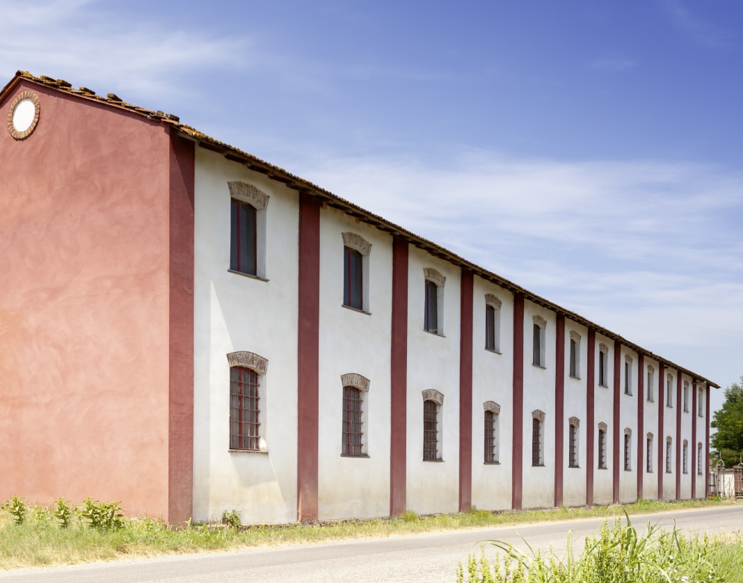 Grande edificio per la lavorazione del riso a Mede, su due piani, di colore bianco e rosa antico.